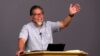 Pastor Tom Ruiz teaching Deuteronomy 13:1-5 with a raised hand and big smile